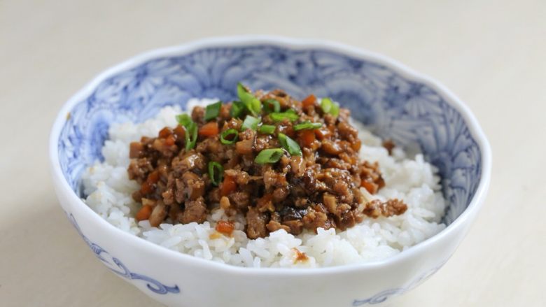 香菇肉酱饭,盛一碗米饭,将香菇肉酱盛于米饭上,撒上葱花,吃的时候拌开即可。