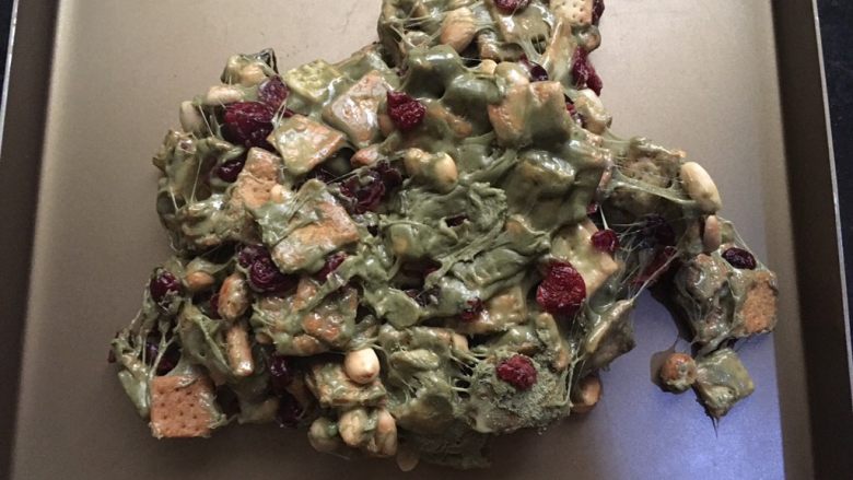 抹茶味雪花酥(内含饼干做法),倒入金盘中后,带上手套揉匀,尽量让糖包裹住每个材料,让材料均匀的分布在糖里