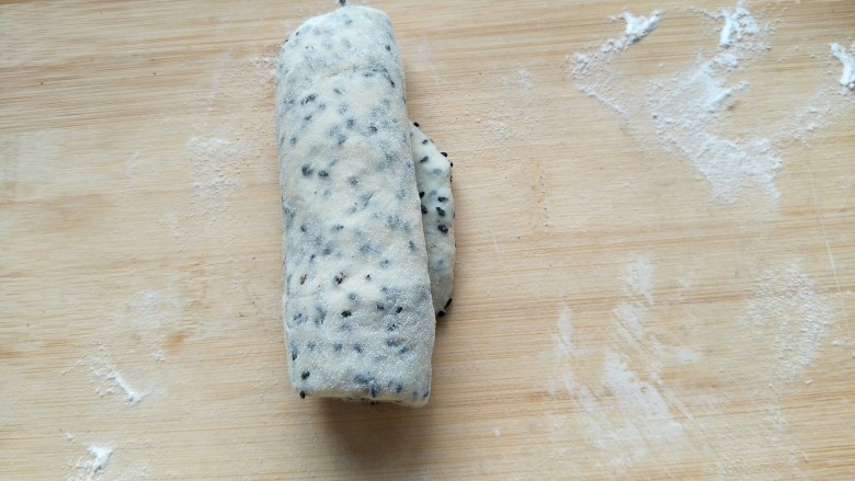 黑芝麻牛奶土司,然后卷起来,三个依次全部卷起来后再盖保鲜膜松弛十到二十分钟。
