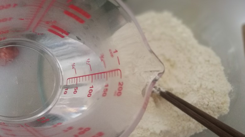 快手辅食-面疙瘩汤,取60ml开水加入面粉中,一边加一边画圈搅拌