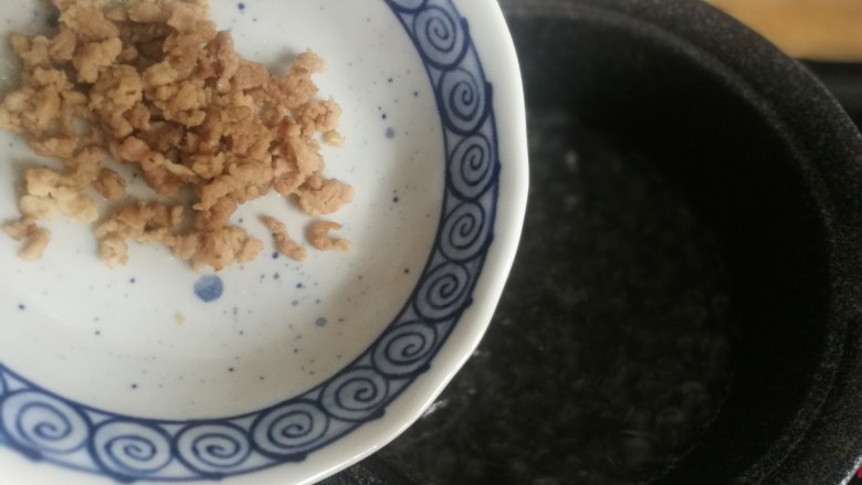 快手辅食-面疙瘩汤,锅内加水,水开后加入肉沫