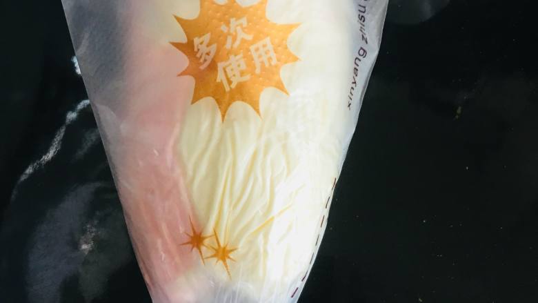 6寸双色蛋糕,卷起保鲜膜,将它放入装好花嘴的裱花袋中。