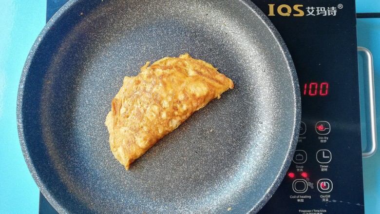 金针菇蛋饺,等到底部凝固,上面的蛋液还有少许未凝固的时候,对折压紧,继续小火慢慢烙,直至熟透出锅(对折后可以用筷子在蛋皮两面搓几个孔,压实,可以让未凝固的蛋液流出来,更容易熟透)