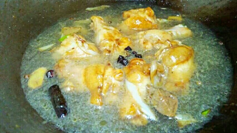 红烧鸡翅根,加清水,没过鸡翅根,将舀出的八角桂皮等倒入,盖上锅盖烧。