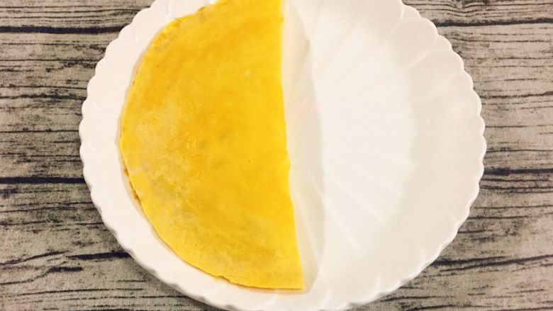 百变鸡蛋+蛋包饭,再将另一半蛋饼掀起来覆盖到炒饭上,成为一个半圆形。