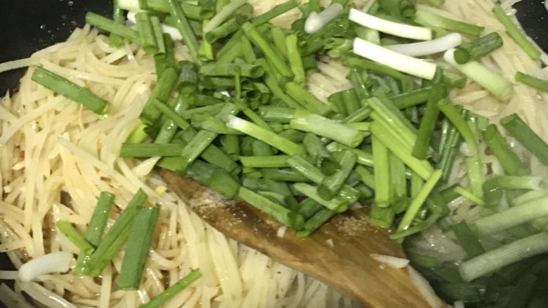 家常小炒—酸辣土豆丝,倒入葱段。再次翻炒均匀,马上过来起锅。