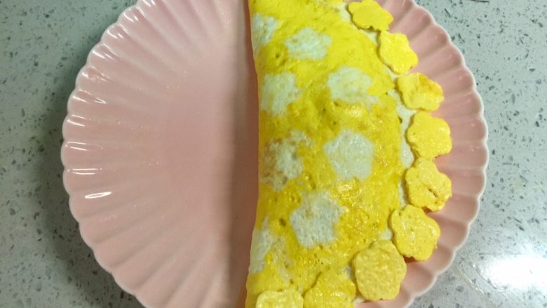 百变鸡蛋+小花茄汁蛋包饭,把蛋皮盖上炒饭,边缘压一压,再把之前压出的小花摆在边上。