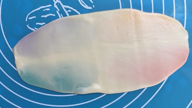 彩虹乳酪蛋黄酥,面团静置好,取一个面团擀成牛舌状,要从中间往两边擀