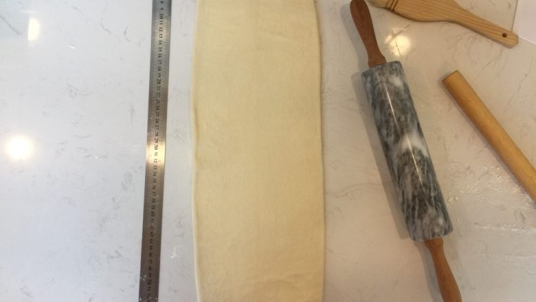 可颂,面团降温好后,将其擀至60x20的长方形,并将刚刚处理好的黄油置与中间。