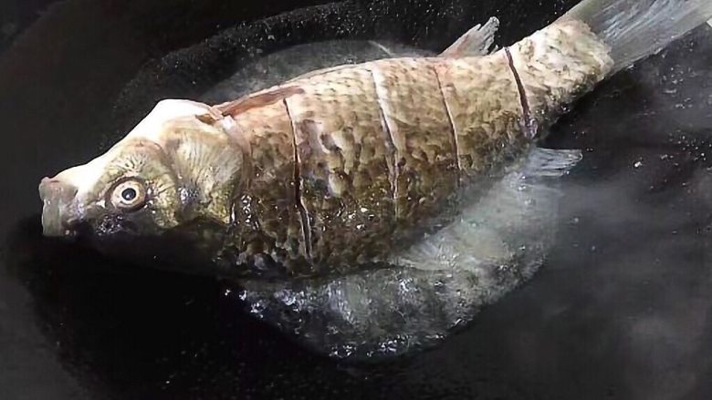 家常菜鲫鱼豆腐,锅里放油,撒适量盐,鲫鱼放入锅中