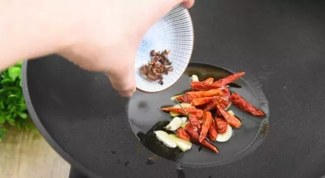 是厨房新手都能很好掌握的下饭下酒好菜——回锅香肠,油锅倒入少许油,下干辣椒、蒜、花椒,爆香