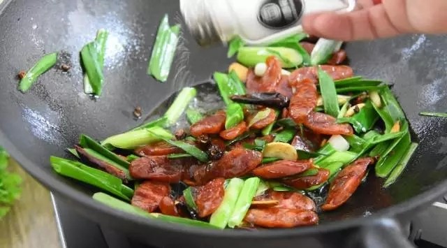 是厨房新手都能很好掌握的下饭下酒好菜——回锅香肠,撒入少许盐,再次翻炒均匀即可