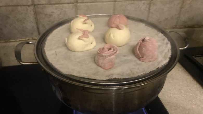可爱的小兔子,粉红面团多了
揪成小劲子
擀成饺子皮
搭叠着
从一侧卷起
中间一刀
成两朵玫瑰花
上屉盖盖蒸