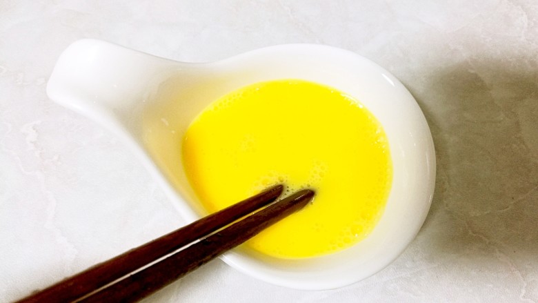 酒酿桂花粉红鸡蛋丸子,另取一碗,打入一个<a style='color:red;display:inline-block;' href='/shicai/ 9'>鸡蛋</a>,用筷子搅打均匀。