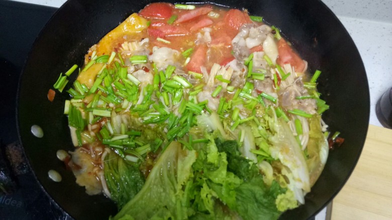 酸辣双色肥牛金针菇扯面,煮至肥牛断生后放入生菜和蒜苗段,加入适量香油关火。