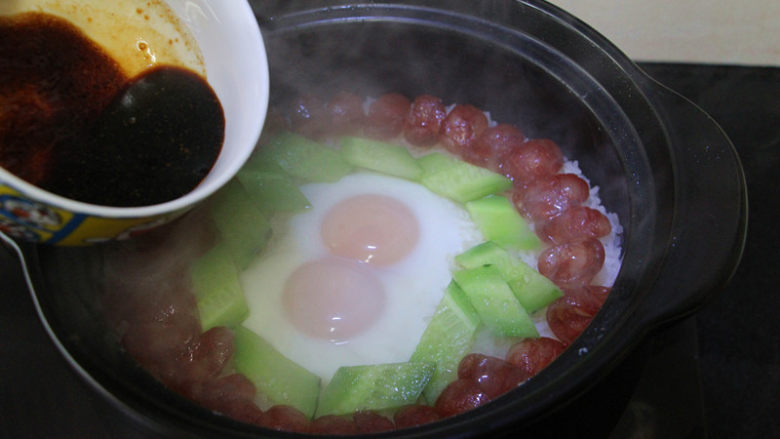 广式腊肠煲仔饭,摆入黄瓜,淋上酱汁,关火利用余热焖5分钟。