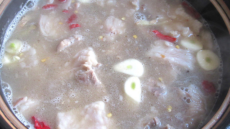 私家御寒羊肉砂锅粉丝煲,羊肉放进砂锅内,并倒入煮羊肉的高汤和少许温水