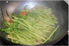 椒丝腐乳通菜,腐乳炒出香味后,倒入通心菜梗,大火翻炒,1分钟内即可断生,菜梗将要全部断生时,加入菜叶部分和剩余的青红椒丝同炒;