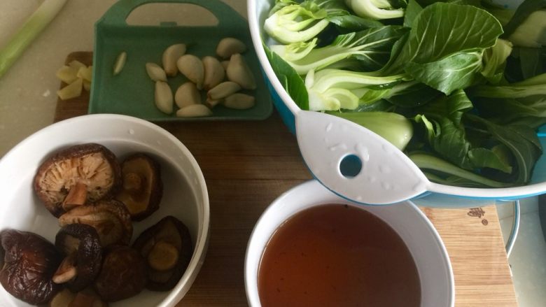 蚝油香菇青菜,青菜纵切一分为四,清洗干净,蒜剥皮清洗,泡发好的香菇捞出挤去水份备用,泡发香菇水保留