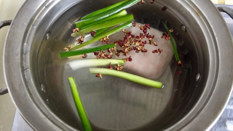 青笋回锅肉,锅中放清水葱段,花椒,姜,五花肉,中火