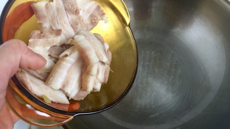 青笋回锅肉,热锅加一点油润一下锅,加入五花肉片煸炒出油,肉片切的足够薄的话,可以受热卷起像小灯盏