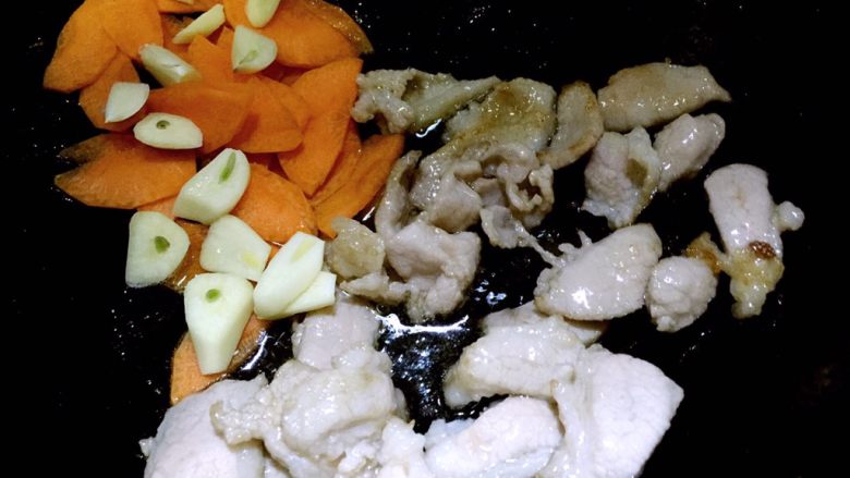 黑木耳炒白菜,肉片变色后,放入蒜片和胡萝卜片翻炒几下