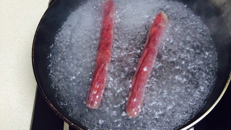 莴笋炒腊肠,开火加入小半锅水,加入洗净的腊肠,煮沸