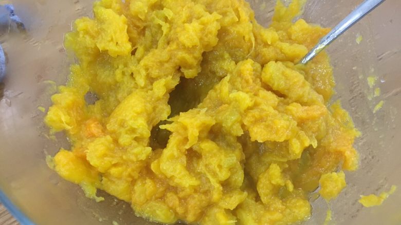 简单又好吃的南瓜饼,乘热用勺子把白砂糖和南瓜搅匀并捣烂;