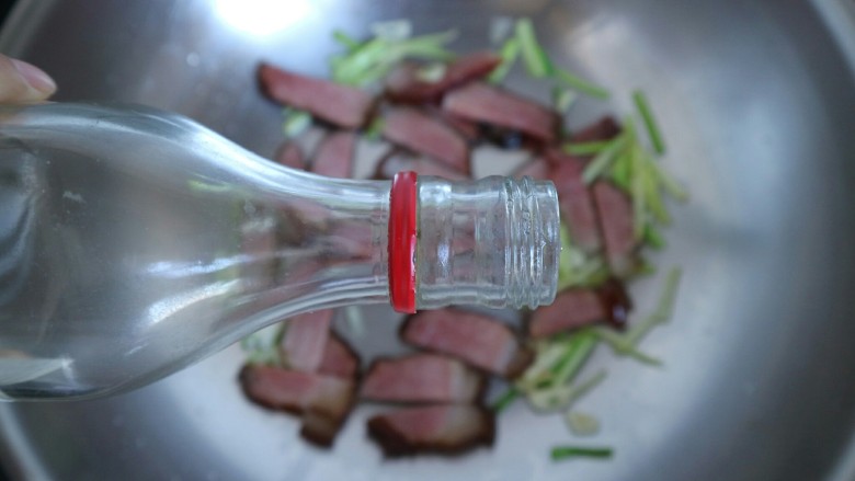 下饭利器~萝卜干彩椒烧腊肉,倒入适量<a style='color:red;display:inline-block;' href='/shicai/ 718'>料酒</a>,翻炒均匀。