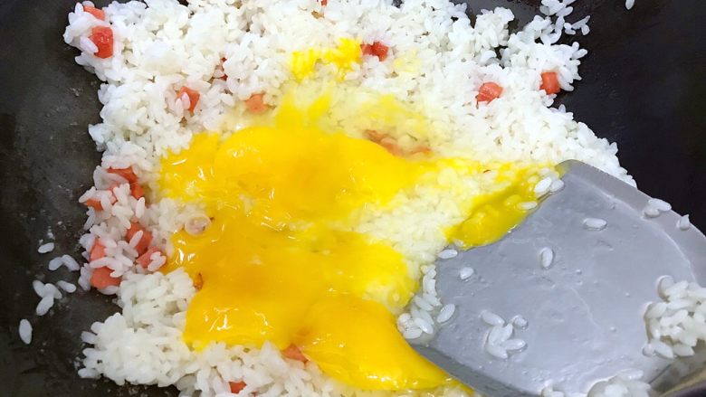 炒饭秀~黄金混蛋炒饭,用锅铲把鸡蛋液铺开来