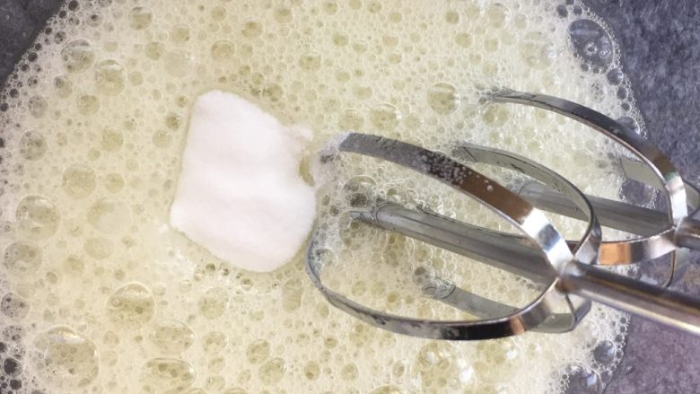 大理石戚风蛋糕,蛋白打发至鱼眼泡时第一次加入细砂糖。
50克细砂糖分3次加入。