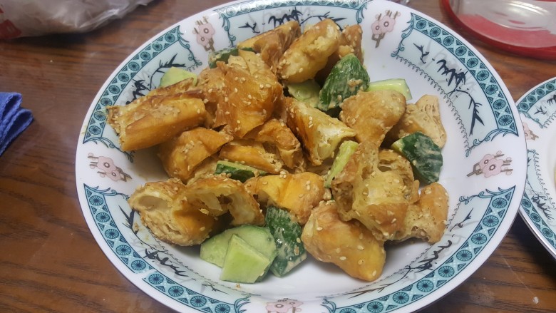 将军菜(油条的吃法),把热好了的芝麻油条和黄瓜倒入调好的麻汁里面,趁着油条酥脆,赶紧拌匀,呈盘就行了