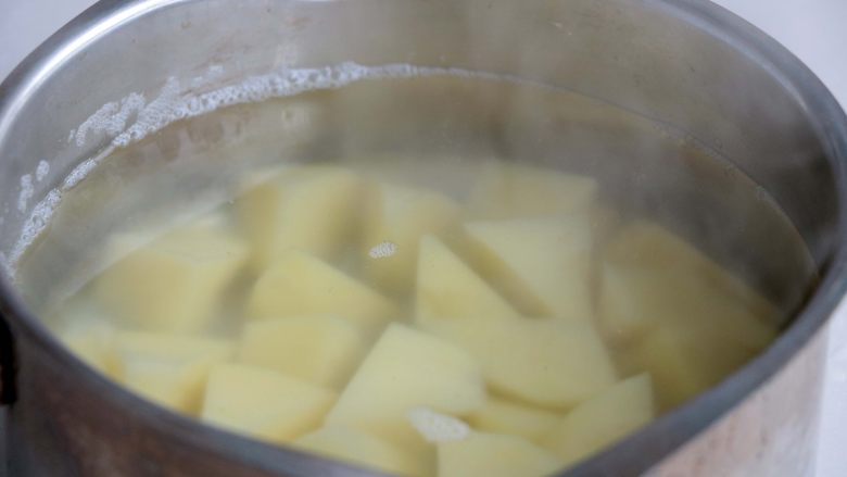 『土豆茄子煲』,土豆开水煮熟,捞出后沥干水分;