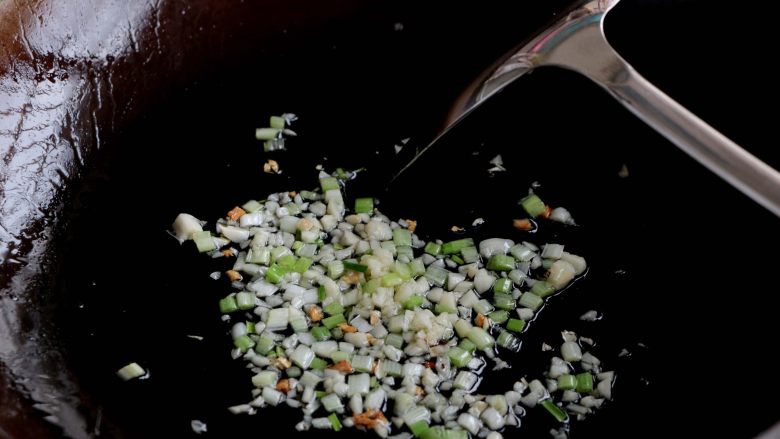 『土豆茄子煲』,锅内留少许的油,放入葱白、大蒜沫炒出香味;