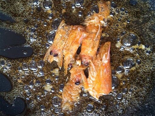 炒饭秀(芝士虾仁炒饭/焗饭),平底锅内倒入适量的油,放入虾头,小火煸出虾油(每次做虾,我都用虾头这样,香一点。不喜欢的也可以省略这部)