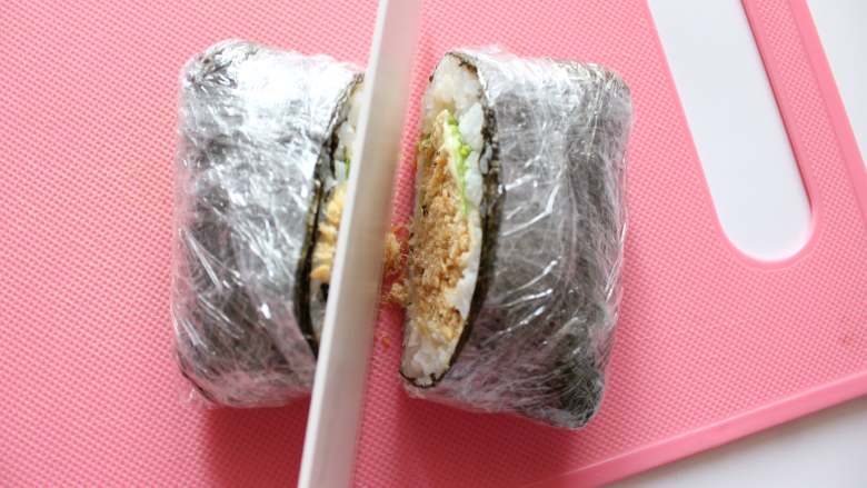 紫菜芝士饭团(适合24个月龄以上的宝宝),带着保鲜膜的状态对切成两半即可(技巧:切下去一点点后略向前方移动着切,这样切面会更干净。也可以把刀子略沾湿再切。)