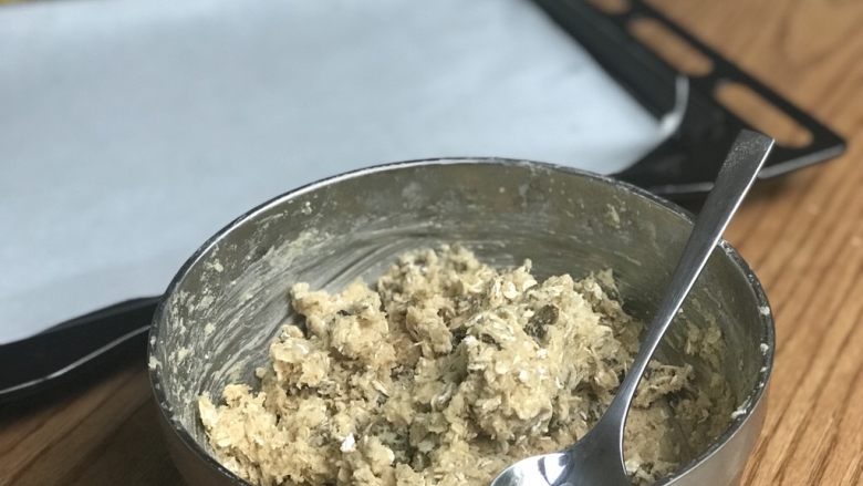 燕麦饼干,30分钟后打开烤箱170度预热、准备烤盘:刷油或用烤纸. 面团从冰箱拿出来并且准备一个干净的汤匙