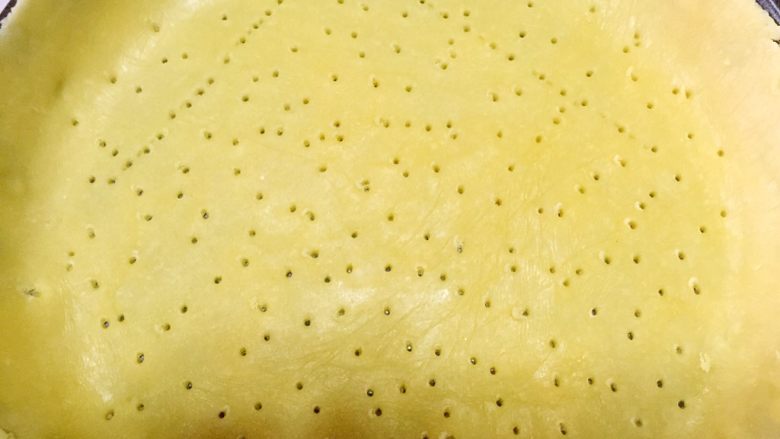苹果派,取其中一片铺入派盘并用叉子扎孔