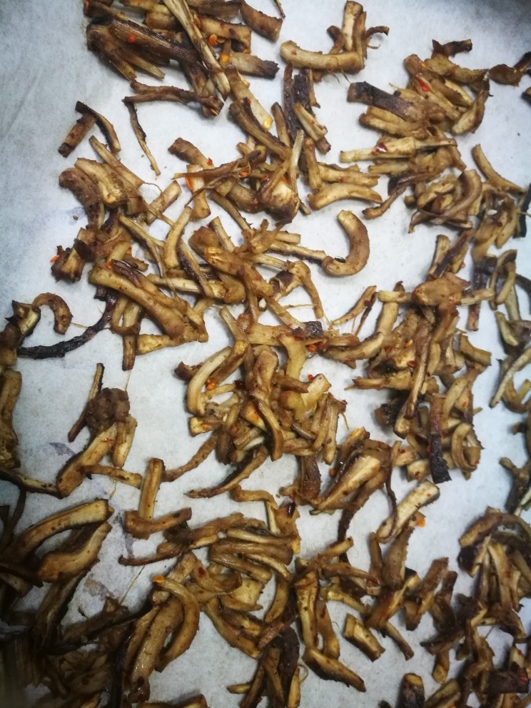 简单快手的拌香菇根,拌好的香菇根平摊在烤盘上,预热180℃,烤五分钟