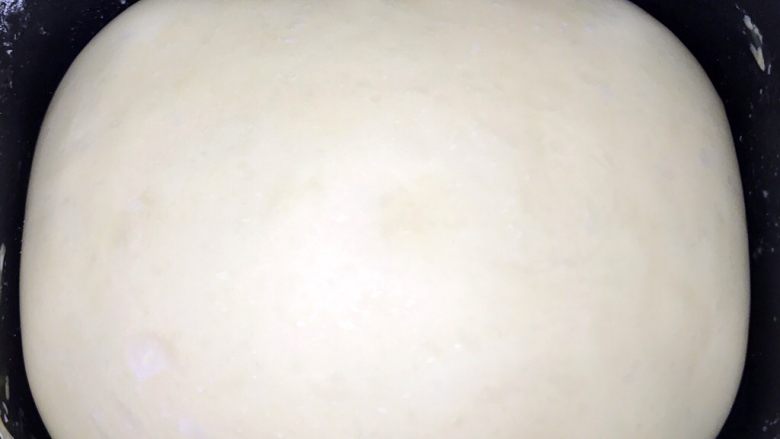 椰蓉蔓越莓圣诞花环面包,面团一般发酵一到两小时,就会发到两倍大。发酵好的面团表面是光滑的。