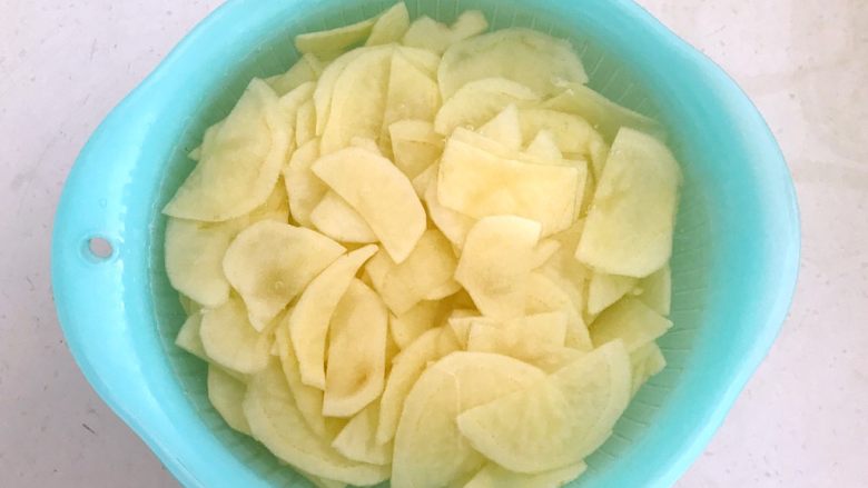 快手菜-腊肉土豆片,把土豆片放入冷水中清洗2次,洗去多余的淀粉