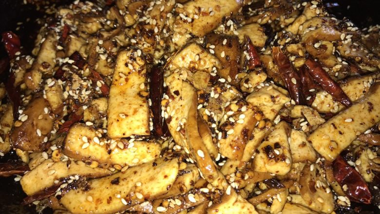 香辣豆干,趁着余温,倒入豆干。用勺子轻轻拌匀,不要用力,豆干会烂的。
