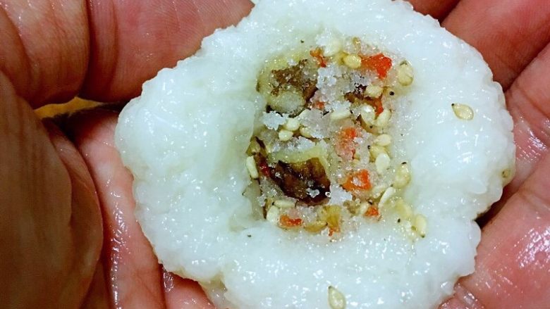 北京+艾窝窝,把米团均匀分成10份儿。米团会粘手,可手沾点儿水防粘。
取一份在手中按扁,放入馅料,馅料不宜过多,不好封口,也腻。