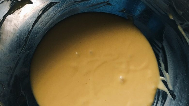 酸奶戚风蛋糕,这时烤箱预热160度上下火十分钟!低粉过筛加入蛋黄盆用手动打蛋器搅拌均匀!搅拌碗状态如图,用打蛋器提起能够跟缎带滴下!
