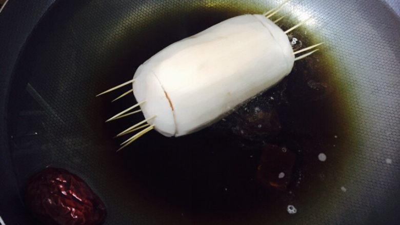 桂花密藕,藕塞满糯米后用牙签固定两端,放入锅中加入没过藕的水量,里面放几颗枣子和几块红糖一起煮水开后中小火煮90分钟左右