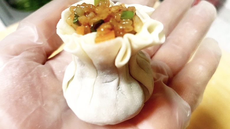 迷你花边糯米烧麦,收好之后拇指和食指圈住烧麦的颈口处用劲捏一下,造型就出来了