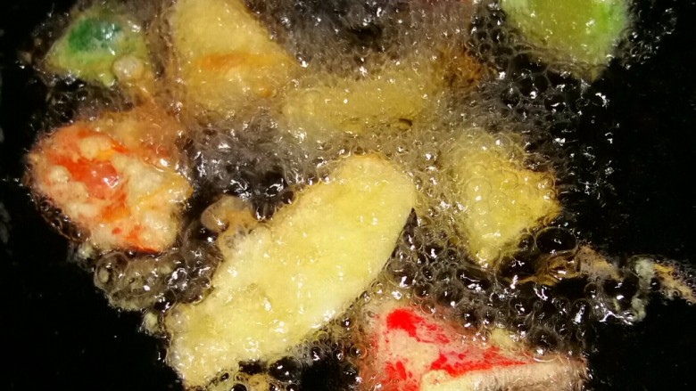 土豆烧茄子,油放锅里烧热,不能太热,怕蛋液被炸糊。调中火,把材料褁上鸡蛋液,放油里炸。