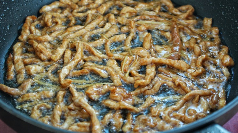 芹菜炒肉丝,锅中放适量油烧热后炒香姜丝,然后放入腌制好的肉丝炒至断生,盛出备用