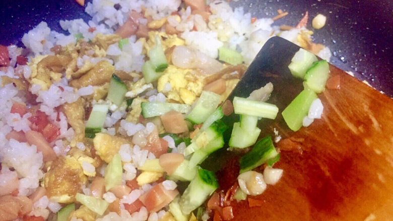 虾仁什锦蛋炒饭,加入黄瓜丁继续翻炒,因为黄瓜超久就要出水汁,所以放在要起锅前加入