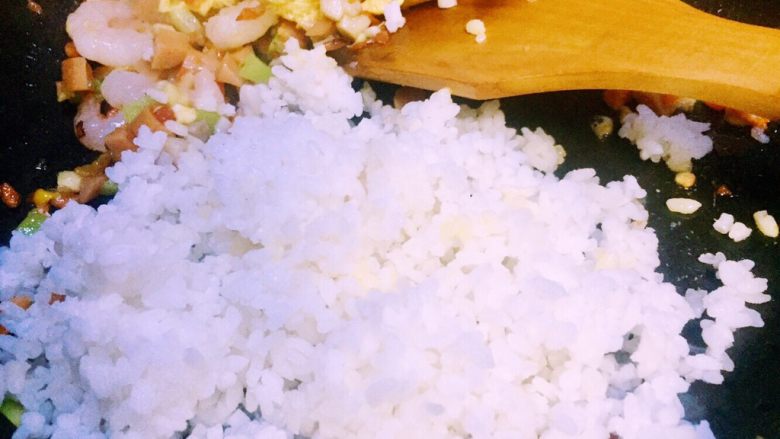 虾仁什锦蛋炒饭,接下来炒好的26全部放在炒好的鸡蛋锅的那边,倒入蟹田大米饭(大米饭均可)翻炒热散籽